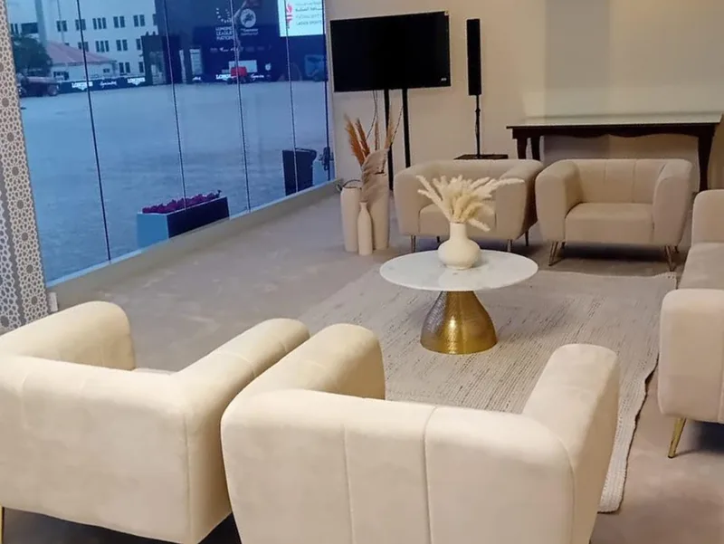 Neutral hospitality lounge with Audrey sofas, armchairs and marble coffee table for VIP guests.
