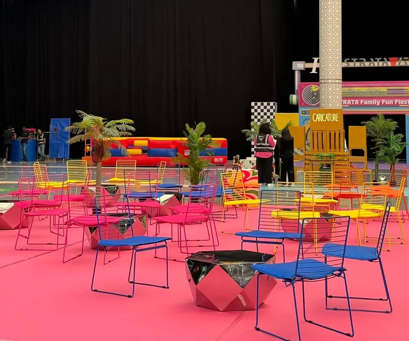 Vibrant Arrow chairs arranged within a themed outdoor hospitality environment.