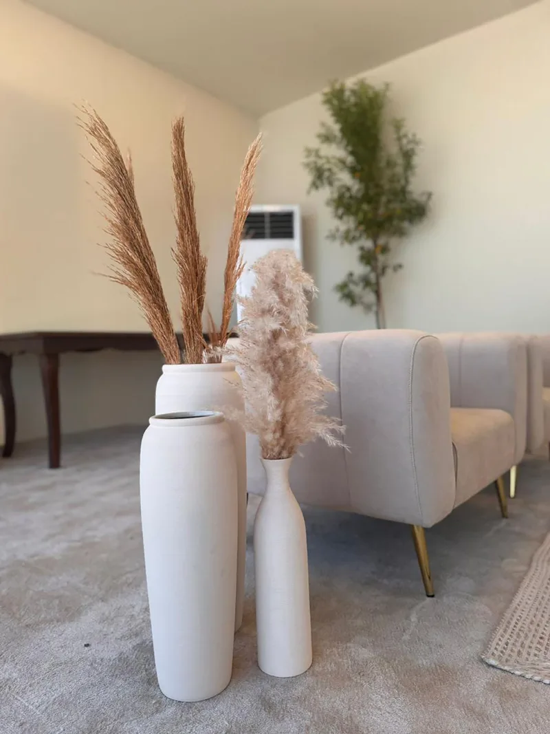 Sophisticated lounge styling with neutral furniture and decorative dried floral arrangements.