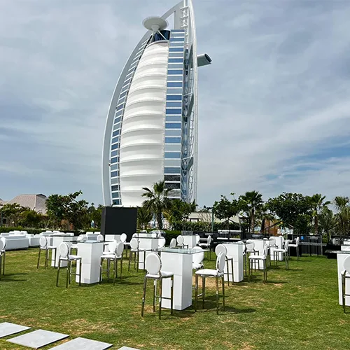 White hospitality furniture arranged for a premium outdoor gala dinner venue.