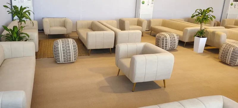 Premium cream sofa grouping arranged around curved wooden coffee tables at XP Music Futures